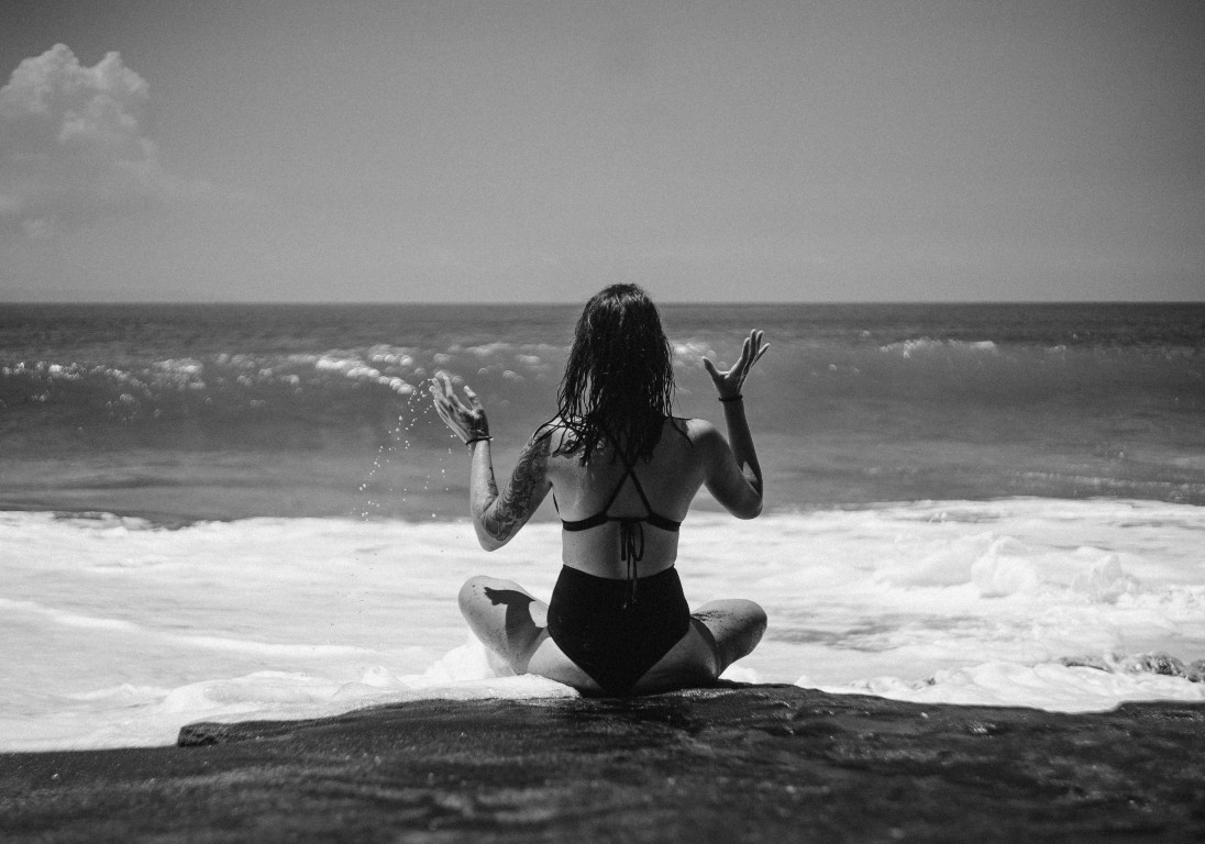 Girl on the oceanfront meets a wave