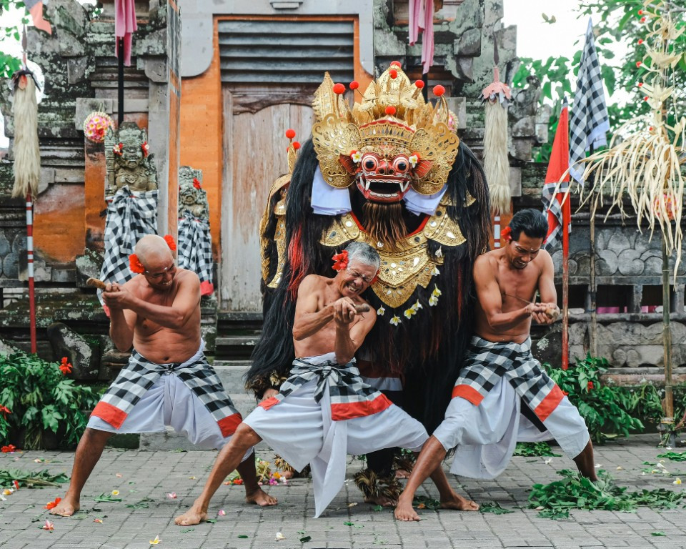 A group of men performing a dance in front of a building
