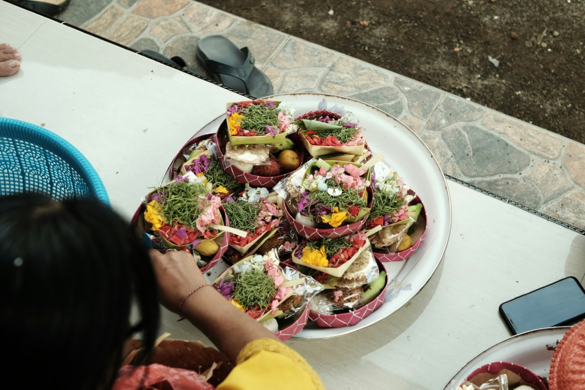 a plate of offerings on a table with a person looking at it